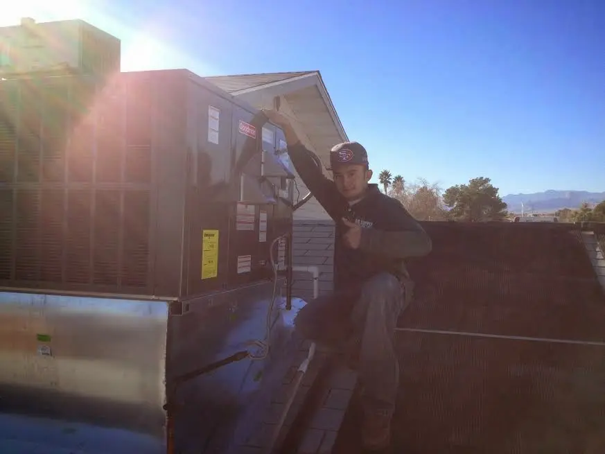 HVAC technician performing Boiler Repair on a rooftop unit in Weddington